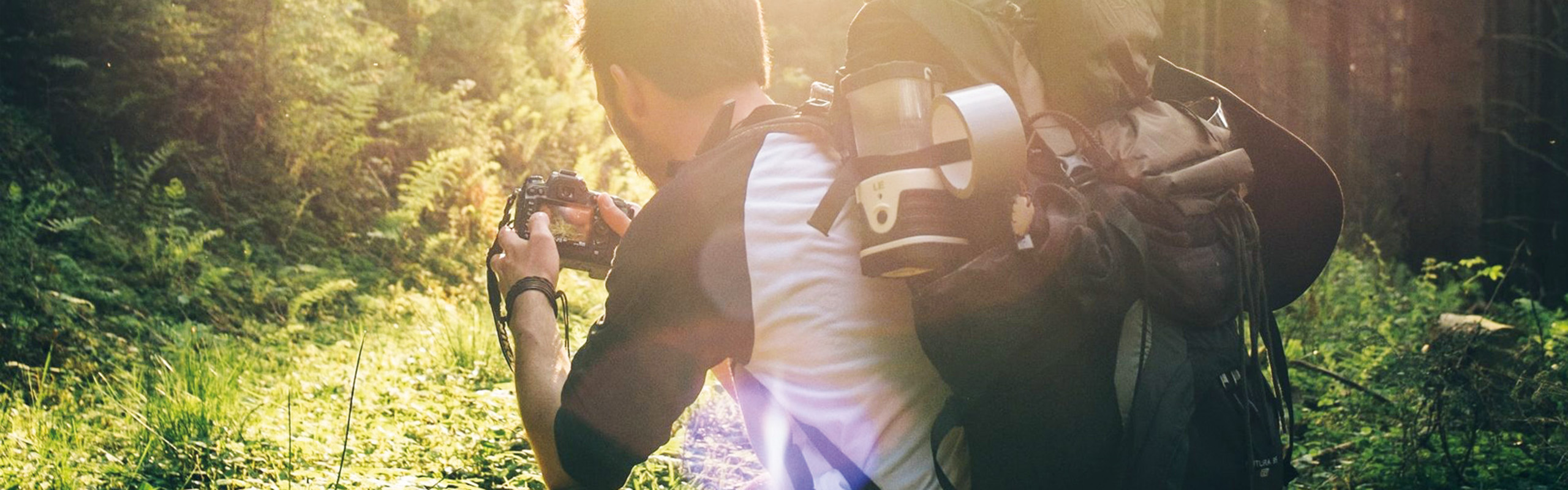 Mann fotografiert im Wald.